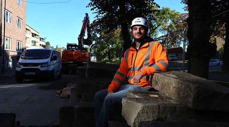 Anthony Khalil sitter på en trave återbrukad kantsten som kommer användas när norra Kungsgatan byggs om och öppnas upp för trafik. 