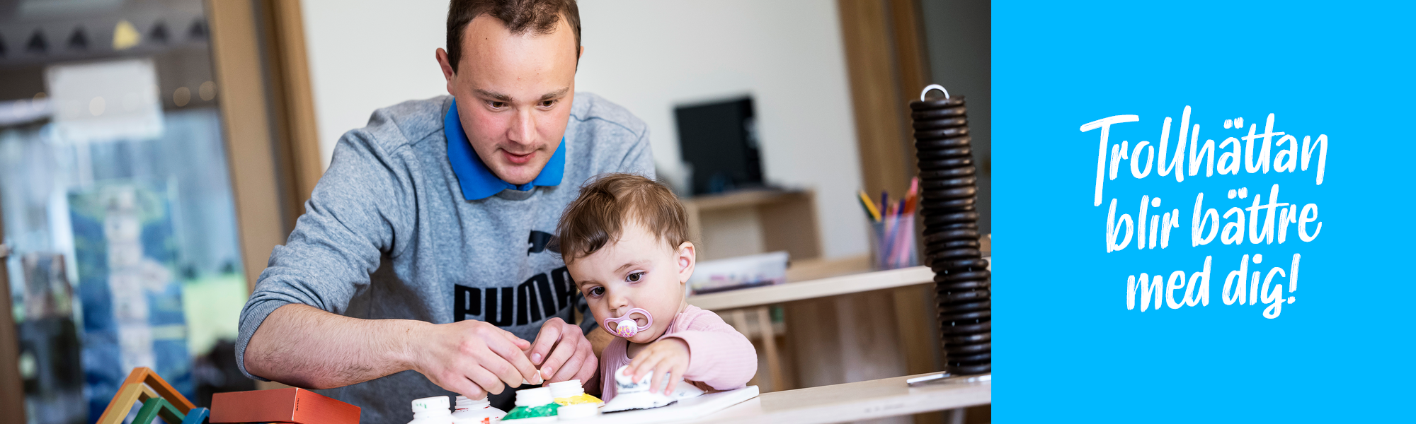 Pedagog sitter och leker med ett barn. Trollhättan blir bättre med dig!