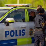 ungdomar i polisuniform står vid polisbil