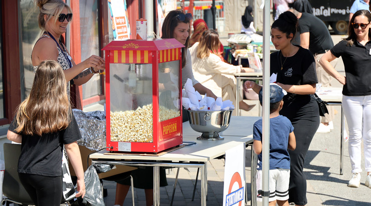 Personer delar ut popcorn till besökare.