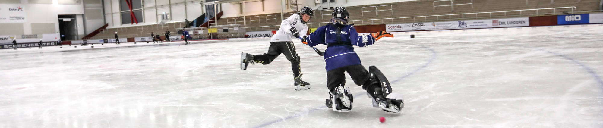 Två personer spelar bandy på is.